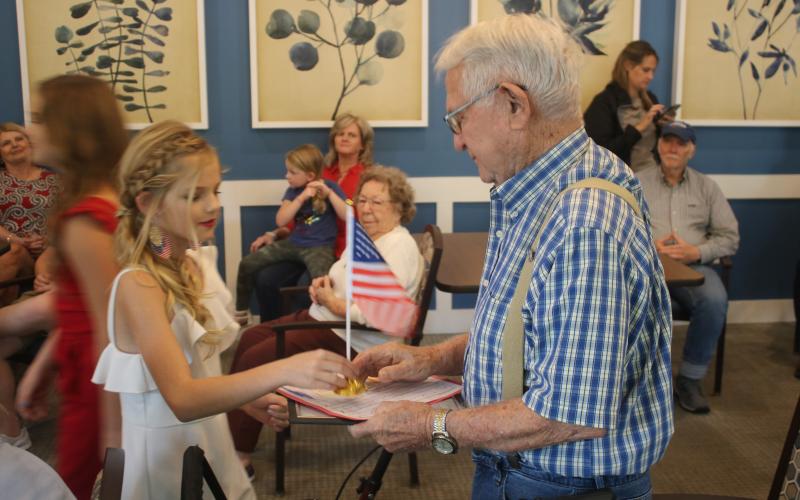 Jocelyn Jenkins (left), 12, presents John Cruise, an Army veteran, with a desk flag during a veterans recognition award ceremony at The Canopy. (TONY BRITT/Lake City Reporter)