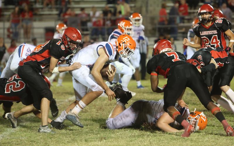 Branford quarterback Thomas Sikes tries to escape a pair of Lafayette tacklers on Oct. 17. (PAUL BUCHANAN/Special to the Reporter)