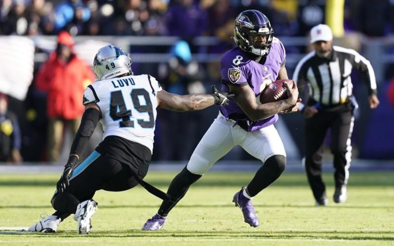 Baltimore Ravens quarterback Lamar Jackson gets by Carolina Panthers linebacker Frankie Luvu on Nov. 20 in Baltimore. (PATRICK SEMANSKY/Associated Press)