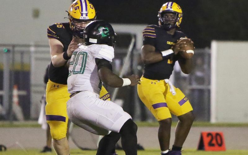 Columbia quarterback Tyler Jefferson (1) drops back to pass while offensive lineman Travis Matthews (56) blocks a Choctaw defender during Friday’s Region 1-3S final. (BRENT KUYKENDALL/Lake City Reporter)