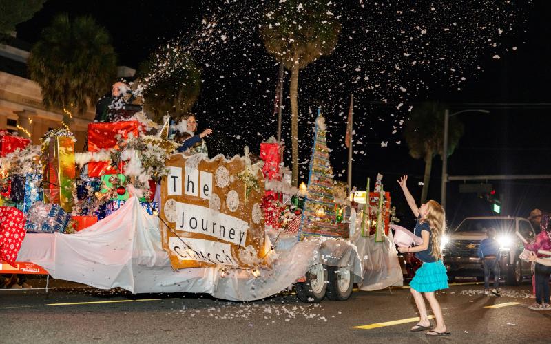 A girl tries to catch ‘snow’ blowing of The Journey Church’s float in the Downtown Christmas parade Saturday night in Mayo. (JACK HOWDESHELL/Special to the Reporter)