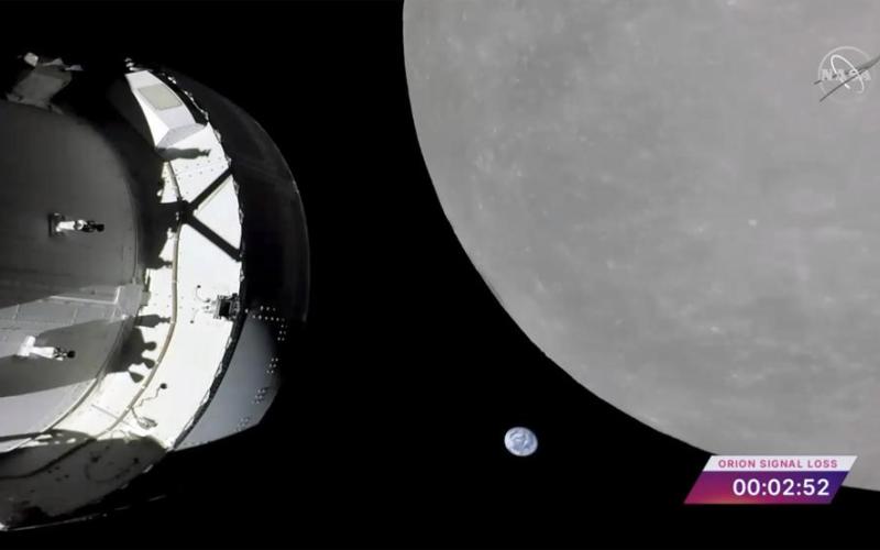 This screengrab from NASA TV shows NASA’s Orion capsule, left, nearing the moon Monday. At center is earth. (NASA via AP)