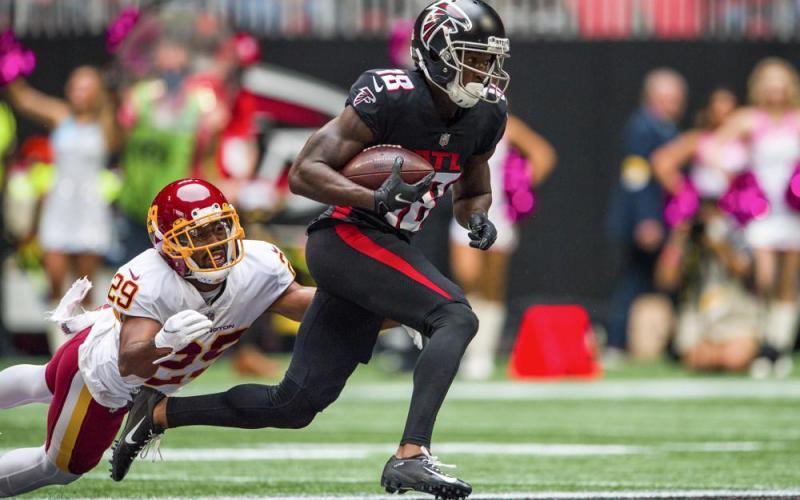 Atlanta Falcons wide receiver Calvin Ridley runs up the field with the ball as Washington cornerback Kendall Fuller dives for a tackle on Oct. 3, 2021, in Atlanta. (DANNY KARNIK/Associated Press)