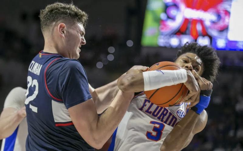Connecticut center Donovan Clingan wrestles with Florida forward Alex Fudge for a rebound during Wednesday’s game in Gainesville. (ALAN YOUNGBLOOD/Associated Press)
