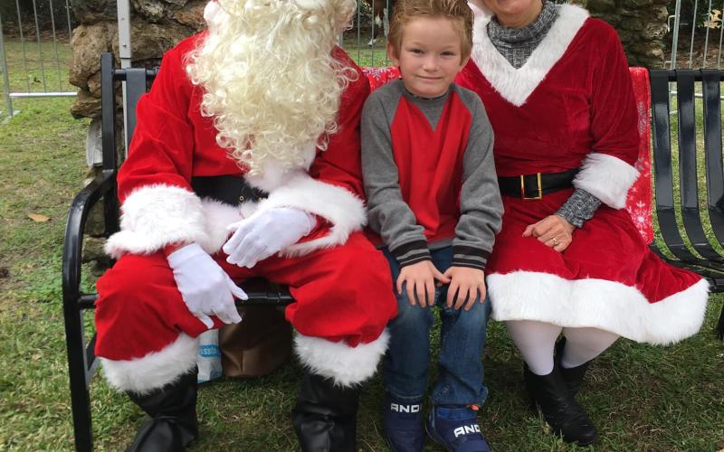 Santa and Mrs. Claus get their picture taken with a child at a previous year’s Christmas at Heritage Park and Gardens event. (COURTESY)