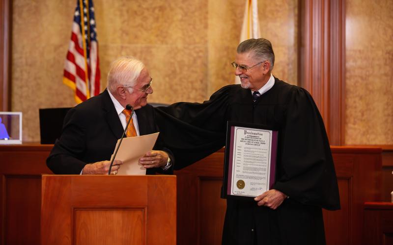 Lake City Mayor Stephen Witt (left) presents retired Third Judicial Circuit Judge Paul S. Bryan with a proclamation honoring Bryan for his three decades of service. (ESTA EBERHARDT/Special to the Reporter)