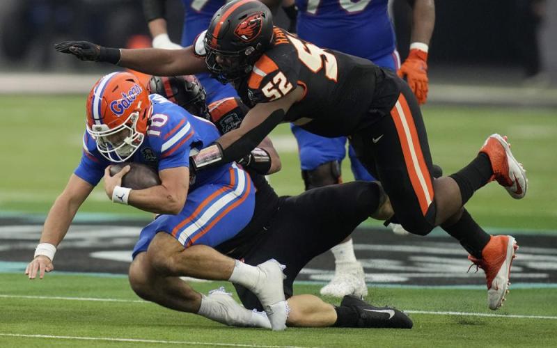 Oregon State defensive lineman James Rawls (52) jumps on Florida quarterback Jack Miller III (10) during the Las Vegas Bowl on Saturday in Las Vegas. (JOHN LOCHER/Associated Press)