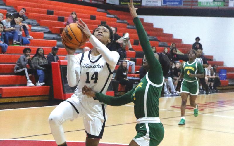 Fort White forward Isreal Hart goes up for a shot against Suwannee guard Janeah Mitchell on Monday night. (MORGAN MCMULLEN/Lake City Reporter)