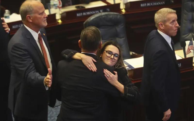 Rep. Bob Rommel (R-Naples) is hugged by Rep. Josie Tomkow (R-Polk City) after his SB 2-A Property Insurance bill he co-sponsored passed Wednesday in the House of Representatives in Tallahassee. At left is Rep. Bobby Payne (R-Palatka); at right is House Speaker Paul Renner (R-Palm Coast). (PHIL SEARS/Associated Press)
