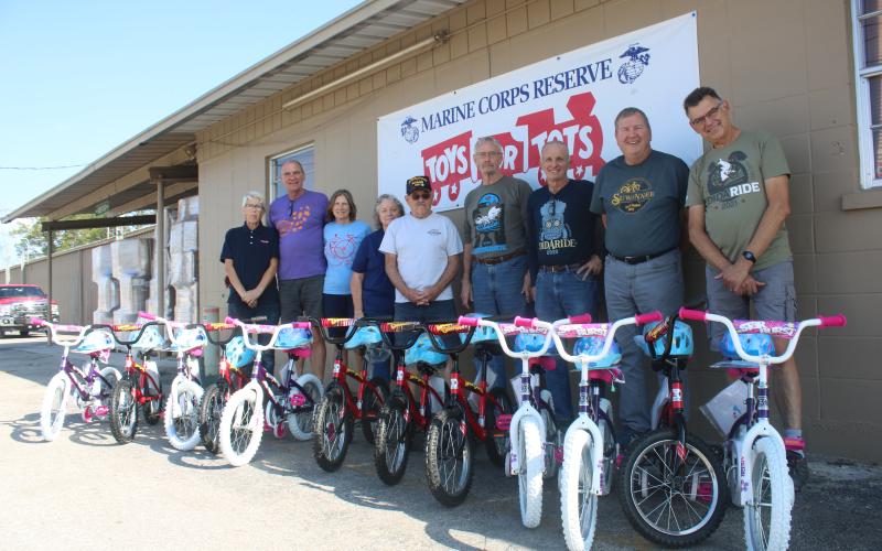 Inga Dwyer (from left), Toys for Tots Coordinator stands with Suwannee Bicycle Association members Mick Shea, Sharon Shea, Nancy Kelley, Mike Kelley, Michael Toffolo, Dale Nanny, George Litteral and Mark Wiencek after they donated 12 bikes to the local Toys for Tots program. (TONY BRITT/Lake City Reporter)