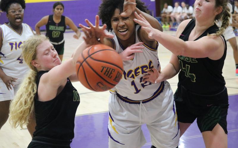 Columbia forward Jolena Gardner (middle) fights for a rebound with Nease guard Camryn Robinson (left) and Nease forward Madilyn Ray on Tuesday night. (JORDAN KROEGER/Lake City Reporter)