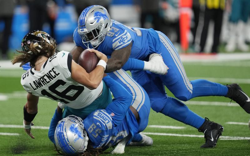 Jacksonville Jaguars quarterback Trevor Lawrence (16) is sacked by Detroit Lions linebacker James Houston (59) and defensive end Josh Paschal (93) during Sunday's game in Detroit. (PAUL SANCYA/Associated Press)