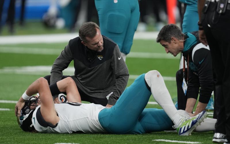 Jacksonville Jaguars quarterback Trevor Lawrence is examined after a sack during Sunday's game against the Detroit Lions in Detroit. (PAUL SANCYA/Associated Press)
