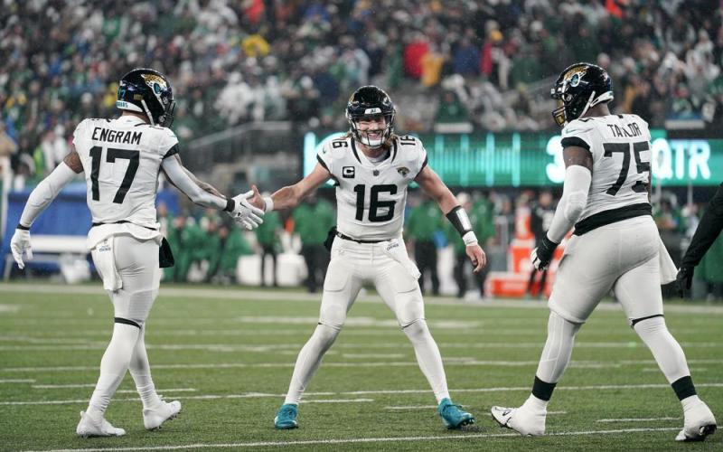 Jacksonville Jaguars quarterback Trevor Lawrence (16) celebrates with tight end Evan Engram (17) and offensive tackle Jawaan Taylor (75) after scoring a touchdown against the New York Jets on Thursday in East Rutherford, N.J. (SETH WENIG/Associated Press)