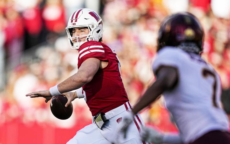 Wisconsin quarterback Graham Mertz throws a pass as Minnesota defensive back Beanie Bishop pressures on Nov. 26 in Madison, Wis. (ANDY MANIS/Associated Press)