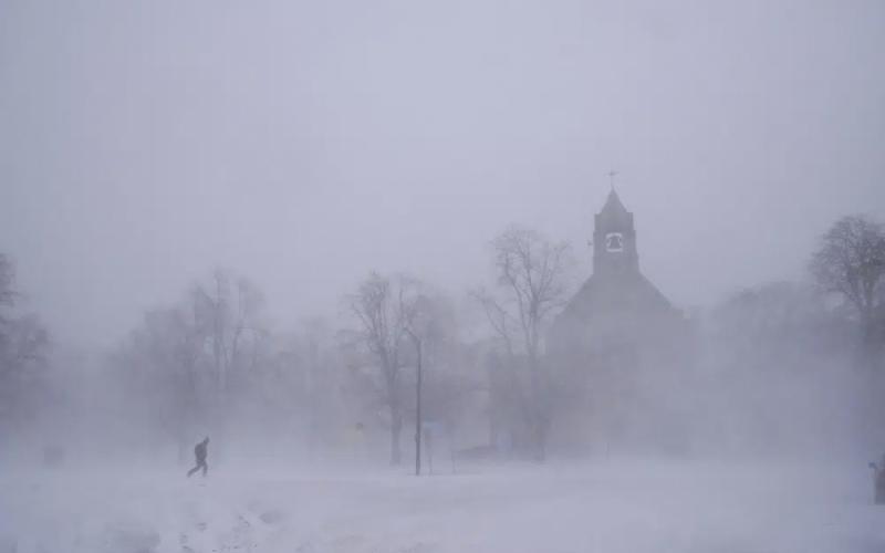 A lone pedestrian in snow shoes makes his way across Colonial Circle as St. John’s Grace Episcopal Church rises above the blowing snow amid blizzard conditions in Buffalo, N.Y., on Saturday. (DEREK GEE/The Buffalo News via AP)