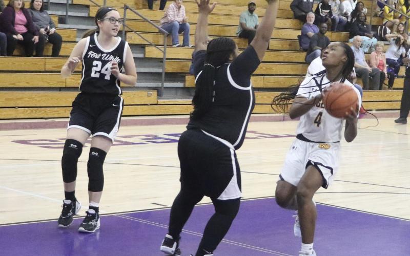 Columbia’s Eriel Baker goes for a layup attempt as Fort White’s N’Coreyia Atkins gets in her way. (MORGAN MCMULLEN/Lake City Reporter)