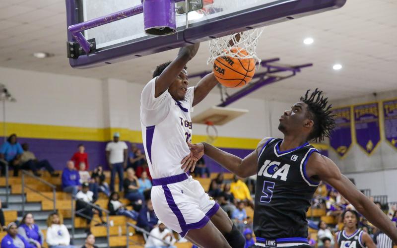 Columbia forward Seth Stockton dunks in front of Impact Christian Academy forward Jordan Mikell on Thursday night. (BRENT KUYKENDALL/Lake City Reporter)