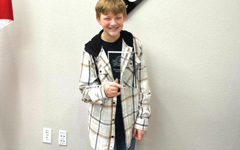 Suwannee Middle Schooler Bradley Harrison poses with his trophy after winning the SCSD Spelling Bee. (COURTESY)