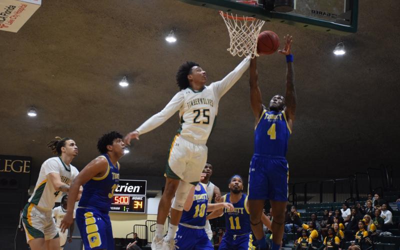 FGC forward Antewan Webber defends a shot from Trinity Baptist forward Marc Maisonnet on Monday night. (COURTESY OF FGC)