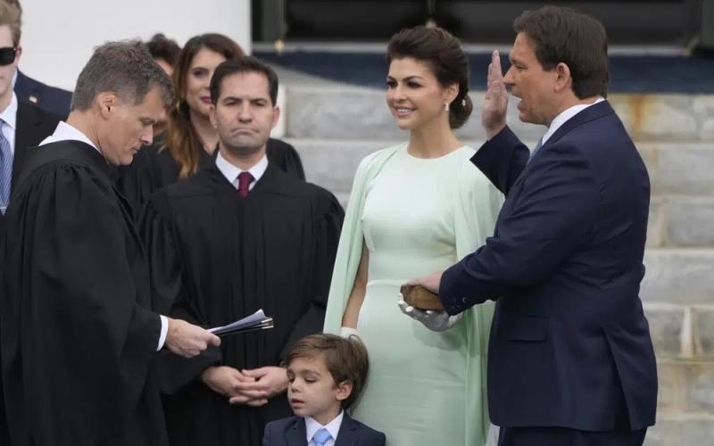 Florida Gov. Ron DeSantis, right, is sworn by Florida Supreme Court Chief Justice Carlos Muniz, left, to begin his second term during an inauguration ceremony outside the Old Capitol on Tuesday in Tallahassee. Looking on is DeSantis’ wife Casey, second from right, and their son Mason. (LYNNE SLADKY/Associated Press)
