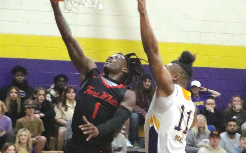 Fort White guard Najeeb Smith make a layup against Union County guard Thomas Williams on Friday. (MORGAN MCMULLEN/Lake City Reporter)