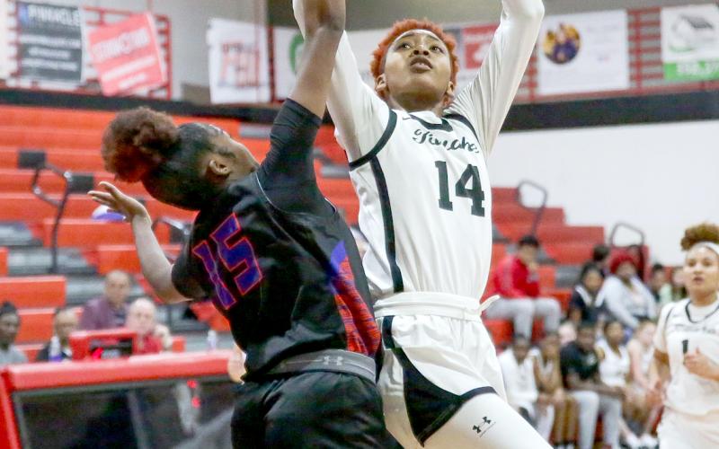 Fort White’s Isreal Hart shoots over Branford’s Zjamyah Wilson on Thursday night. (BRENT KUYKENDALL/Lake City Reporter)