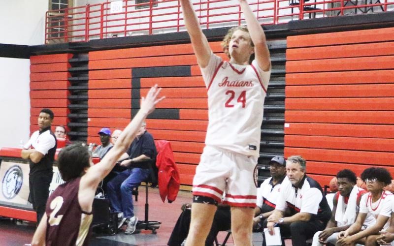 Fort White forward Brandon DeMartino shoots over Oak Hall’s Ryan McKinny on Thursday night. (MORGAN MCMULLEN/Lake City Reporter)