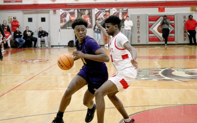 Columbia forward Ty’jahn Wright drives to the basket while defended by Santa Fe forward Antonio Hall on Friday night. (JORDAN KROEGER/Lake City Reporter)
