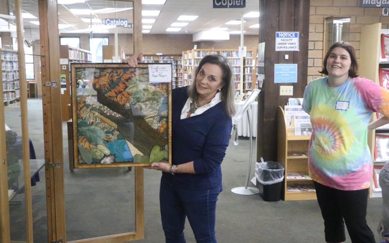 Gayle Rogers shows off a textile art work of an alligator that will be on display at the Columbia County Public Libary’s Main Branch as part of the Lady of the Lake Quilt Guild’s display through Feb. 21. (MORGAN MCMULLEN/Lake City Reporter)