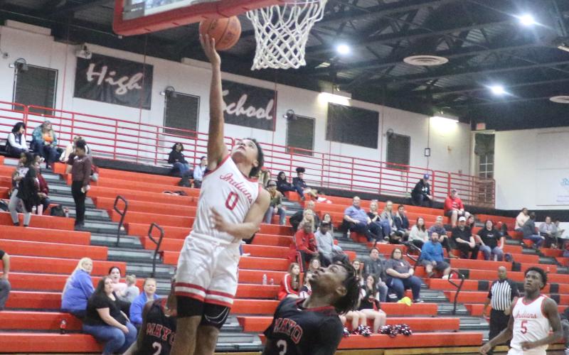 Fort White guard Tafari Moe rises for a layup over Lafayette’s Amarie Fleming on Friday night. (MORGAN MCMULLEN/Lake City Reporter)