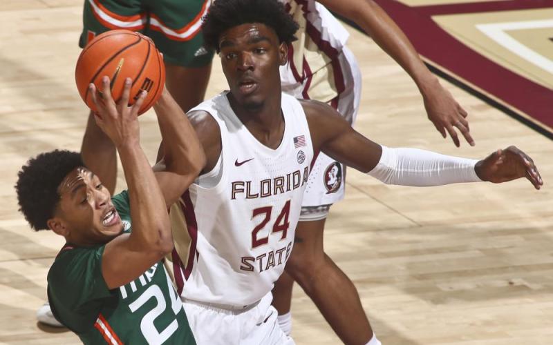 Miami guard Nijel Pack (24) gets a rebound as Florida State center Naheem McLeod (24) looks on during Tuesday's game in Tallahassee. (PHIL SEARS/Associated Press)