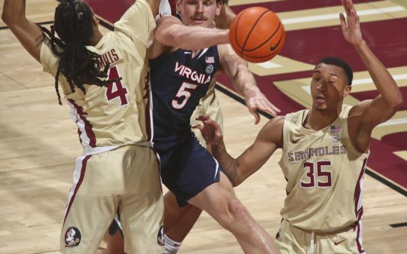 Virginia forward Ben Vander Plas passes the ball as he is triple-teamed by Florida State defenders during Saturday's game in Tallahassee. (PHIL SEARS/Associated Press)