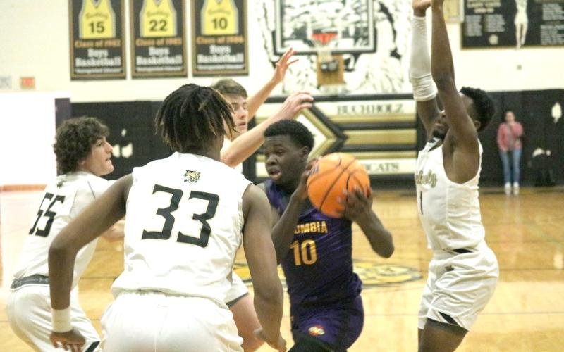 Columbia guard Isaac Broxey drives to the basket surrounded by Buchholz defenders on Tuesday night. (JORDAN KROEGER/Lake City Reporter)