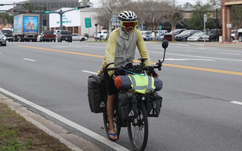 Paul Webb rides down E. Duval Street in Lake City on his way to Jacksonville during his cross-country bicycle ride to raise funds for the Challenged Athletes Foundation. (JAMIE WACHTER/Lake City Reporter)