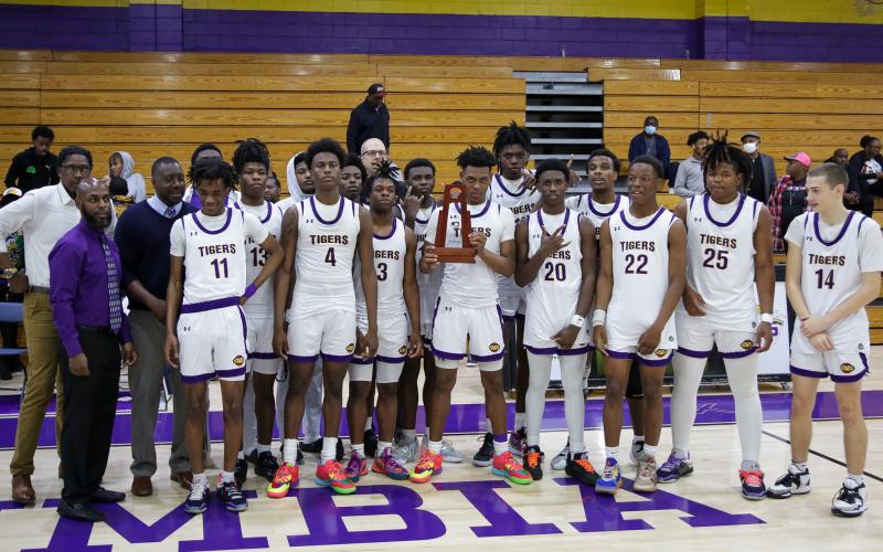 Columbia’s basketball team poses with the District 2-5A championship trophy after defeating Rickards 68-38 on Friday night. (BRENT KUYKENDALL/Lake City Reporter)