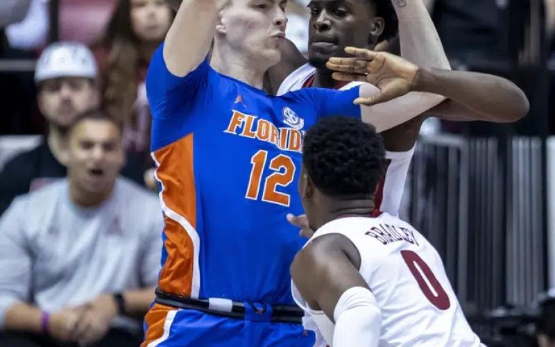 Florida forward Colin Castleton (12) works against Alabama center Charles Bediako, while Alabama guard Jaden Bradley (0) during Wednesday's game in Tuscaloosa, Ala. (VASHA HUNT/Associated Press)