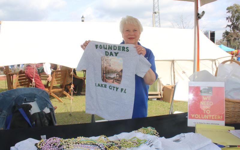 Ann Brown shows off a Founders Day T-shirt during the opening day Friday at the Olustee Festival. (TONY BRITT/Lake City Reporter)