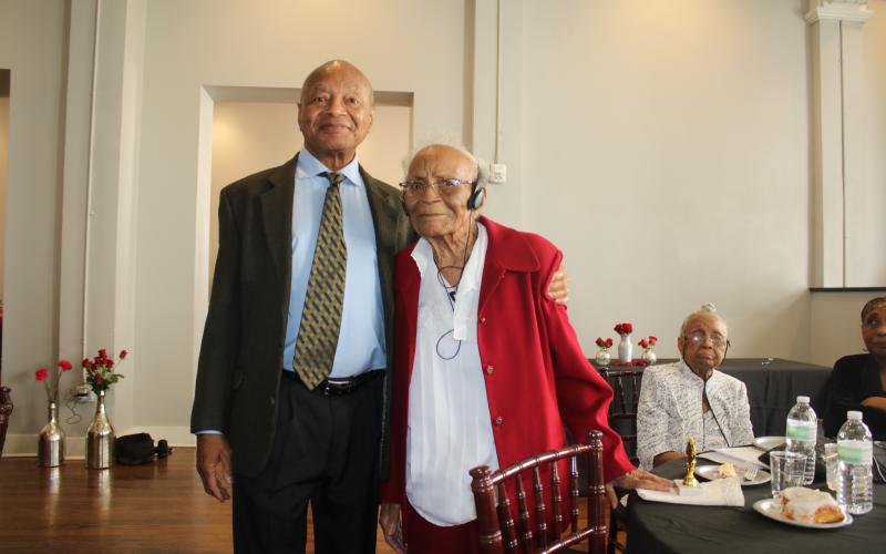 Merril Tunsil stands with his mother, retired educator Joyce Parnell Tunsil, who was recognized as being 95 years old at the Unsung Heroes program. Her sister Mildred Veronica Parnell Tunsil, (sitting background) was also recognized for being older than 90, as well as her brother Donal Parnell, who was siting at the table, for being 99 years old. (TONY BRITT/Lake City Reporter)