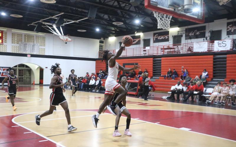 Fort White’s Najeeb Smith goes up for a layup in front of a Williston defender Friday night. (MORGAN MCMULLEN/Lake City Reporter)