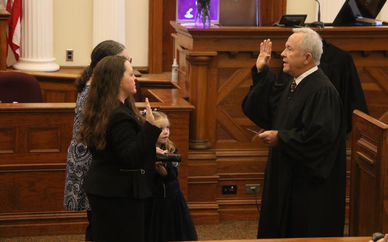 Circuit Court Judge David Fina (right) administers the oath of office to Suwannee County Judge Jennifer Kuyrkendall Griffin on Wednesday as Griffin’s daughter, Kendall, and mother look on. (MORGAN MCMULLEN/Lake City Reporter)