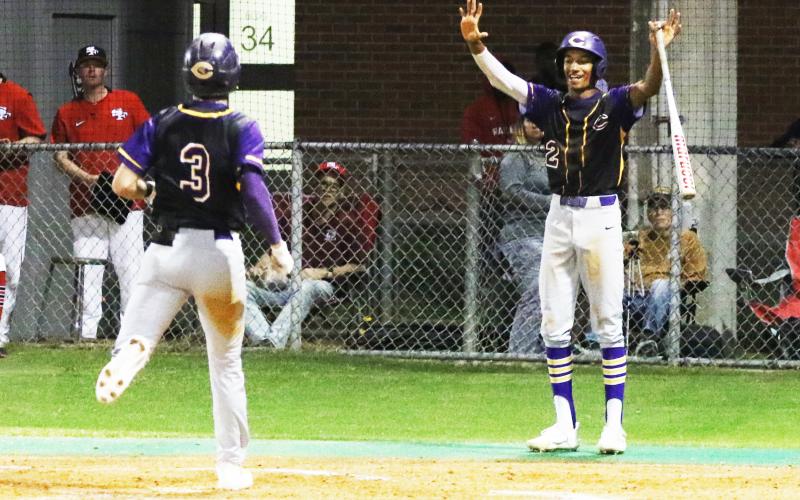 Columbia shortstop (2) Brayden Thomas celebrates as outfielder Carston Palmer (3) scores on an error against Santa Fe on Thursday night. (MORGAN MCMULLEN/Lake City Reporter)