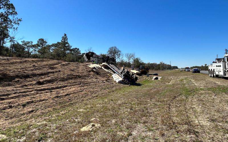 An overturned truck and trailer sit on the side of U.S. Highway 27 in Williston after it hit a median and crashed Thursday afternoon. (COURTESY)
