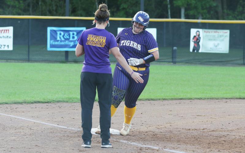 Columbia third baseman Alexis Blair high fives assistant coach Hayes Fulford as she rounds third base after one of her two home runs against Baker County on Monday night. (MORGAN MCMULLEN/Lake City Reporter)