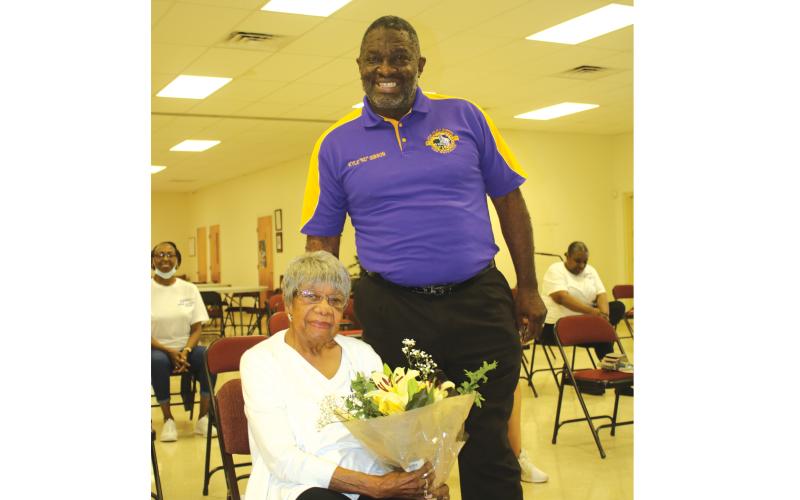 TONY BRITT/Lake City Reporter Francena Robinson Harris,103, holds a bouquet of flowers presented by Rev. Kyle Gibson, who recently visited the Olivet Missionary Baptist Church Health and Wellness group following one of its exercise classes. (TONY BRITT/Lake City Reporter)