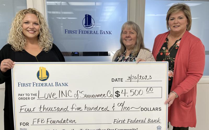 First Federal Bank Financial Manager Heather Thompson (left) and Regional Manager Pam Cochran (right) present Love INC Executive Director Martha Wood a $4,500 grant that will help the Suwannee County non-profit meet its monthly obligations in the community. (COURTESY)