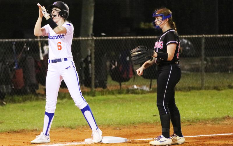 Branford third baseman Madyson Sikes celebrates in front of Fort White third baseman Hannah LeBleu after reaching third base safely on Monday night. (JORDAN KROEGER/Lake City Reporter)