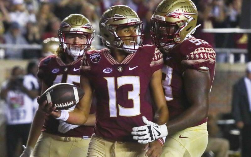 Florida State quarterback Jordan Travis (13) is congratulated by offensive lineman Maurice Smith (53) after scoring a touchdown against Florida on Nov. 25, 2022, in Tallahassee. (PHIL SEARS/Associated Press)