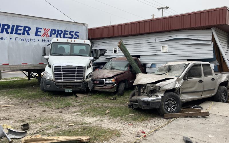 A semi truck and trailer crashed into vehicles at the Auto Unique repair shop Tuesday morning in Mayo, pushing them into the Mayo Laundromat. (COURTESY FLORIDA HIGHWAY PATROL)