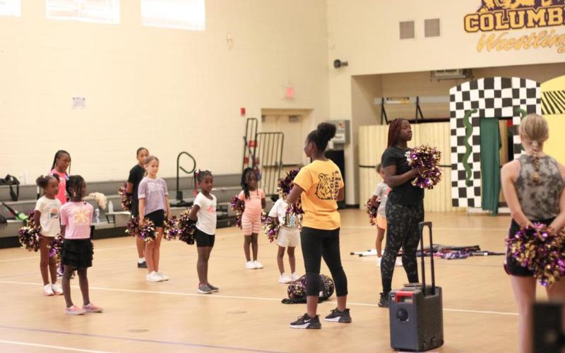 Members of the Columbia High School color guard introduce girls to the activity during a clinic Saturday. (COURTESY)